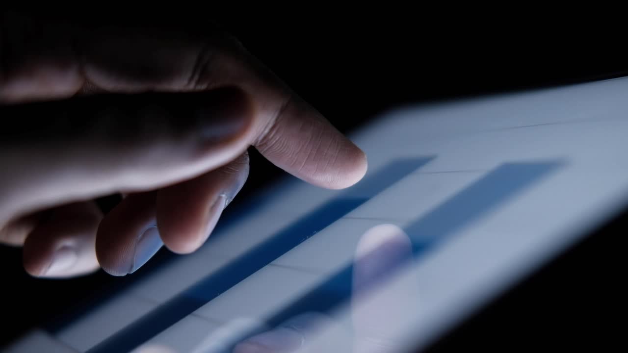 Hand touching a touchscreen tablet with a graph