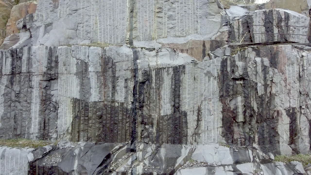 la cámara sube lentamente por la pared de una cantera de granito