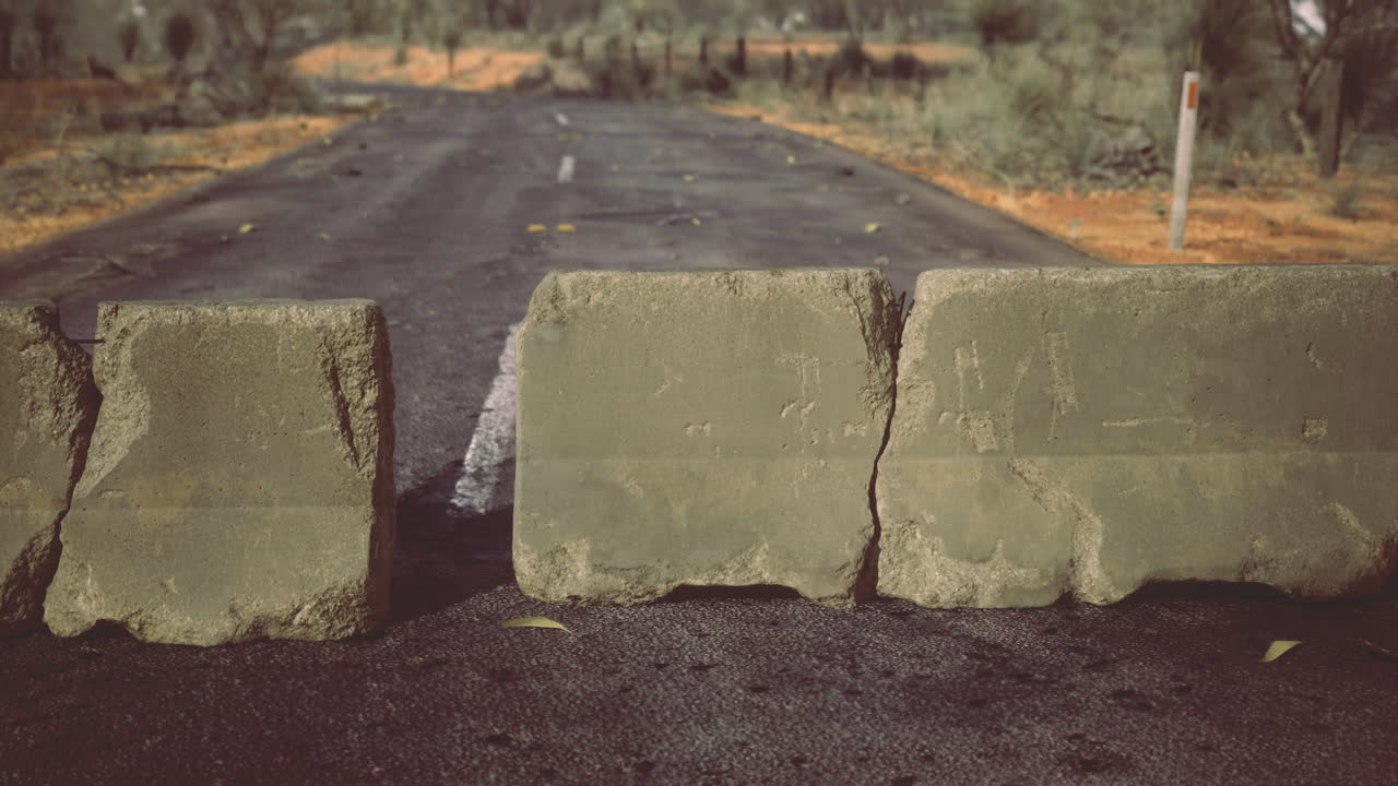 Road barricade blocking a deserted path in a remote desert landscape