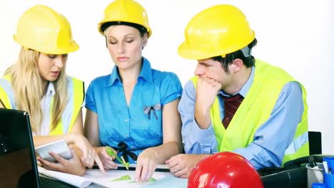 arquitectos estudiando los planos de construcción.
