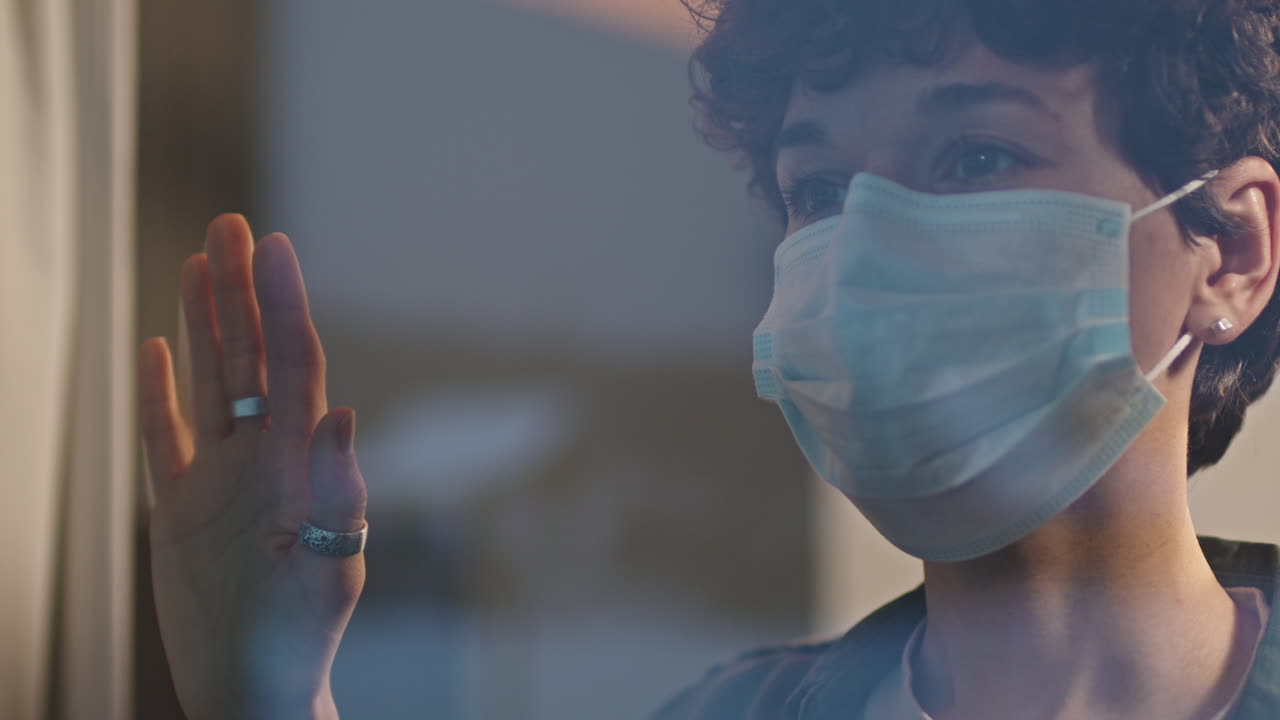Sad Woman In Face Mask Standing Near Window