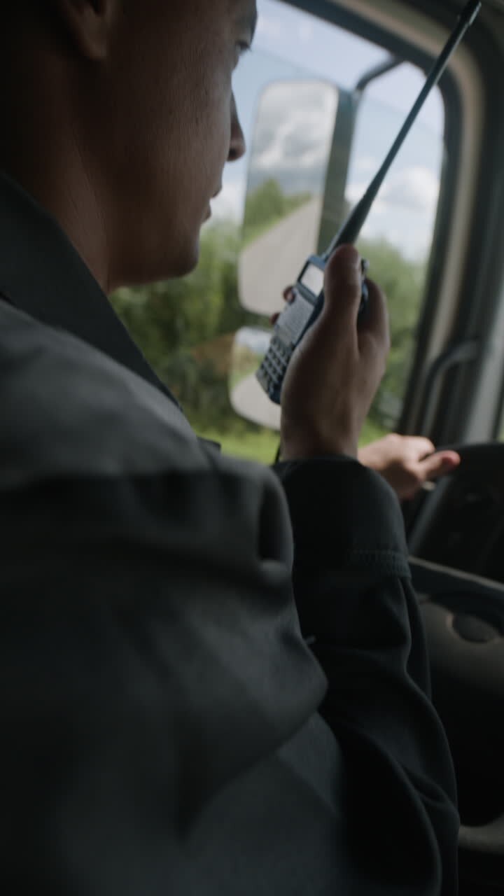 Uomo alla guida di un camion che utilizza una radio