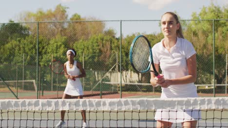 Video-of-caucasian-female-tennis-player-holding-racket-and-training-with-friend