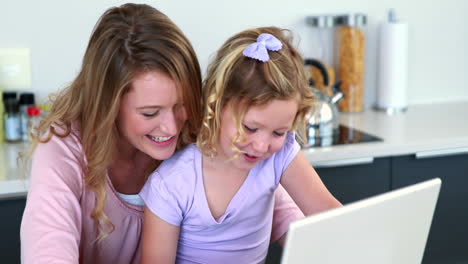 mutter und tochter benutzen gemeinsam einen laptop