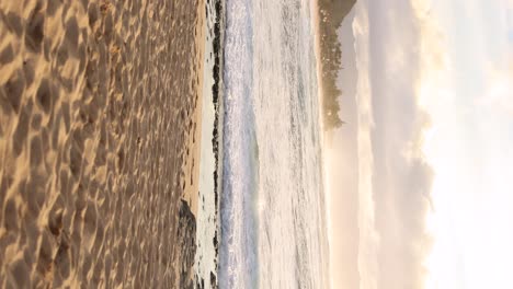 handheld vertical shot of waves crashing on north shore of oahu, hawaii