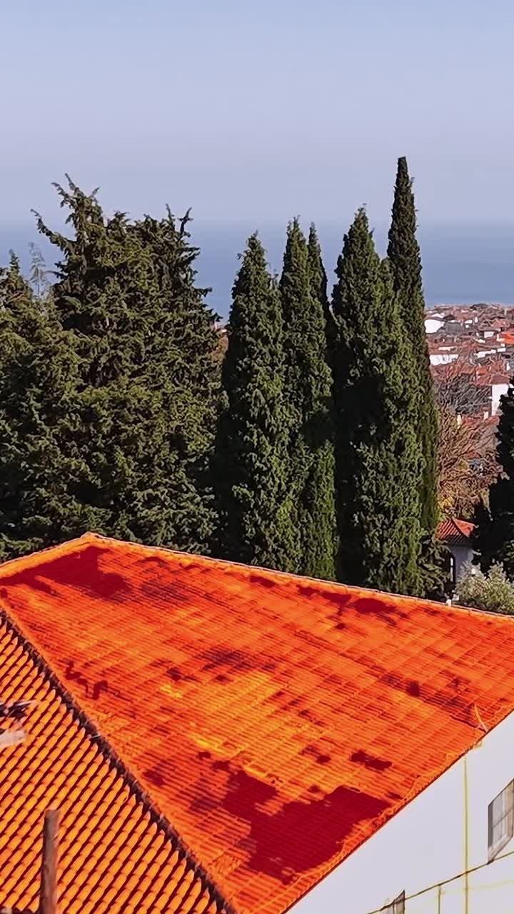 Vista panoramica di un tranquillo villaggio in Grecia con colline e il mare
