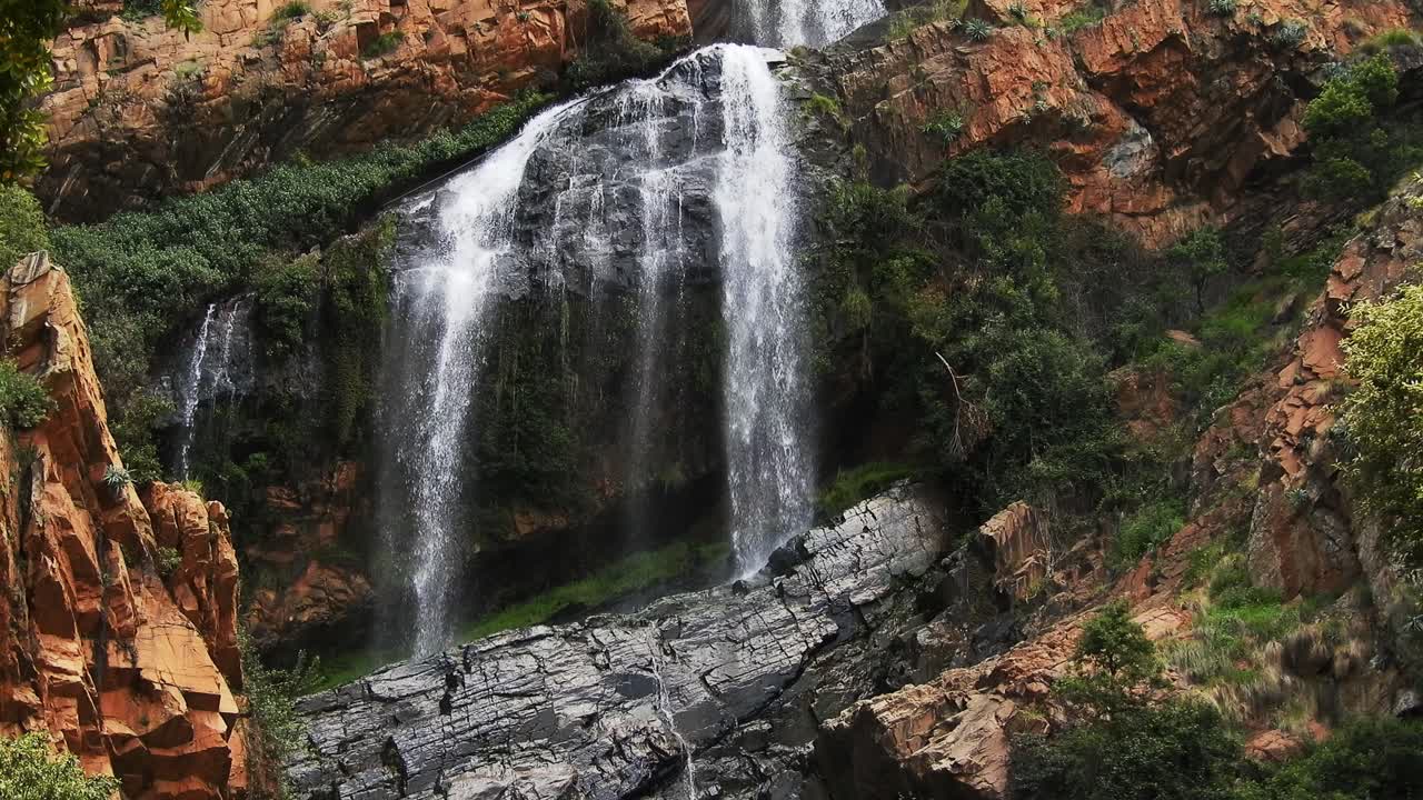 Cachoeira do rio Crocodile fluindo e caindo sobre rochas nos jardins botânicos nacionais Walter Sisulu em Roodepoort, África do Sul.