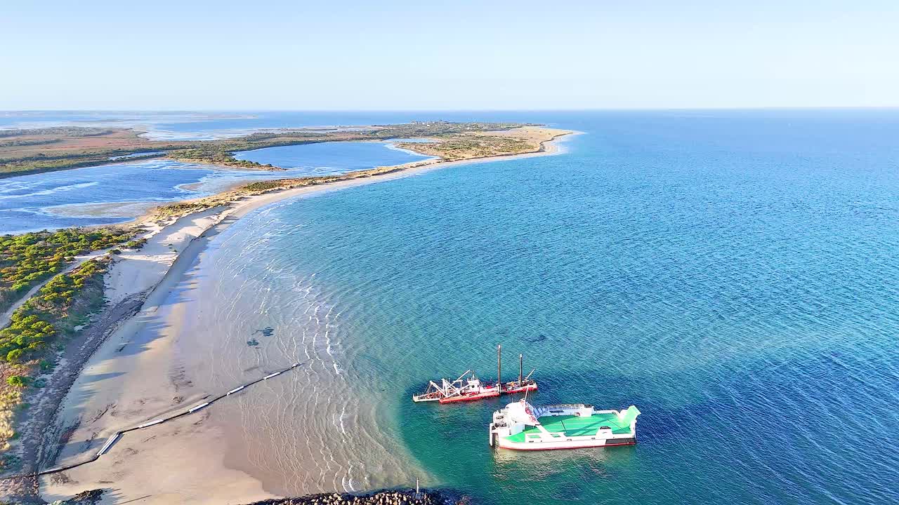 Aerial view of a cargo ship navigating near the Bellarine Peninsula, showcasing serene coastal waters and sandy shores