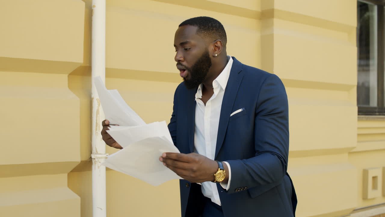 Winner businessman walking outdoors. Afro business man looking documents outside