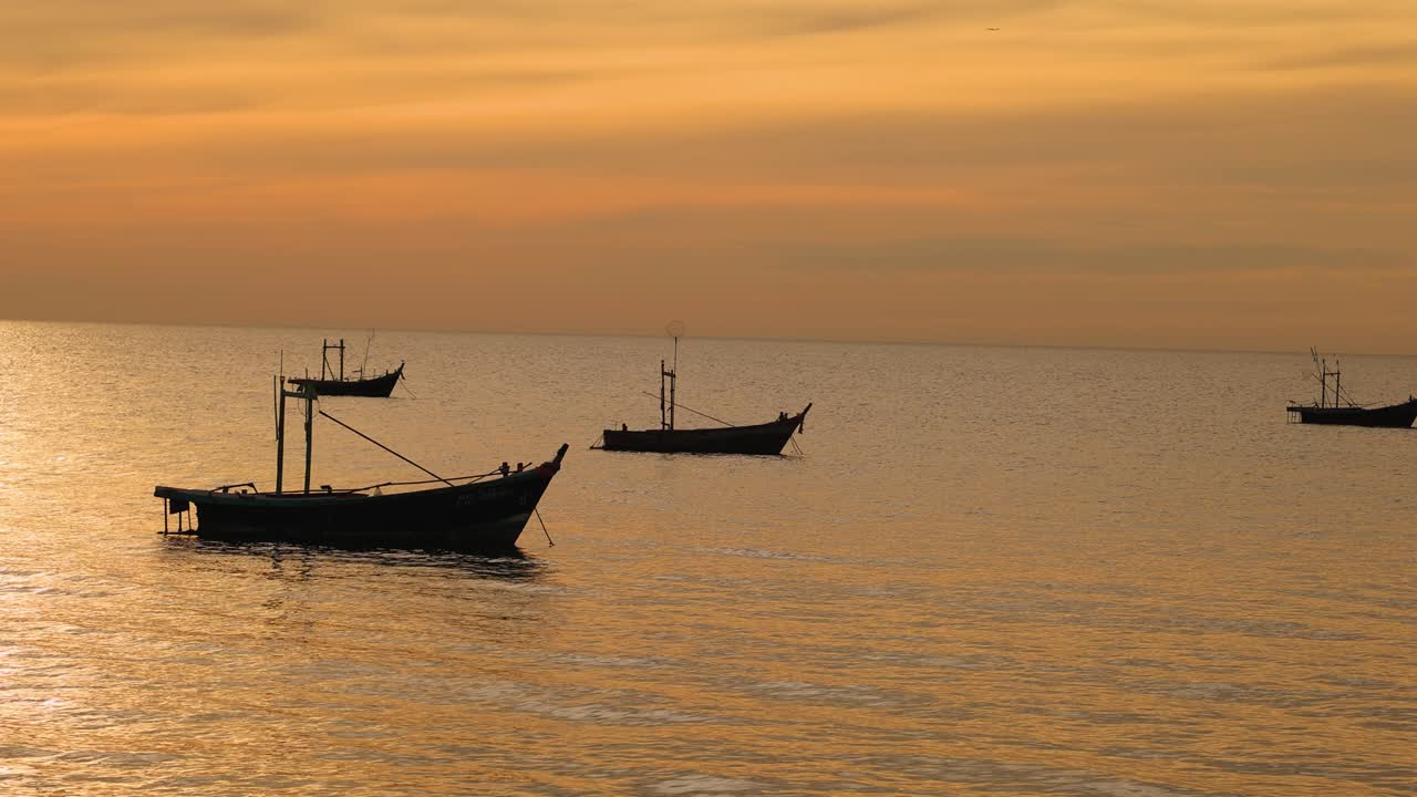 Barche che galleggiano pacificamente durante un tramonto dai colori vivaci.
