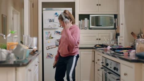 happy-teenage-girl-dancing-in-kitchen-having-fun-celebrating-weekend-performing-funny-dance-moves-listening-to-music-wearing-headphones