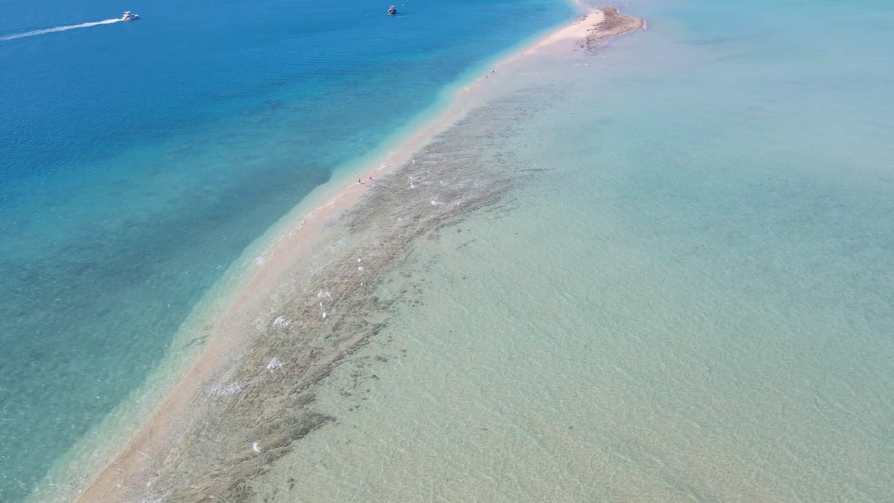 호주 퀸즐랜드의 휘트선데이 관광 명소인 랭포드 섬에서 긴 침을 뱉는 관광객들과 함께 바다에서 항해하는 보트