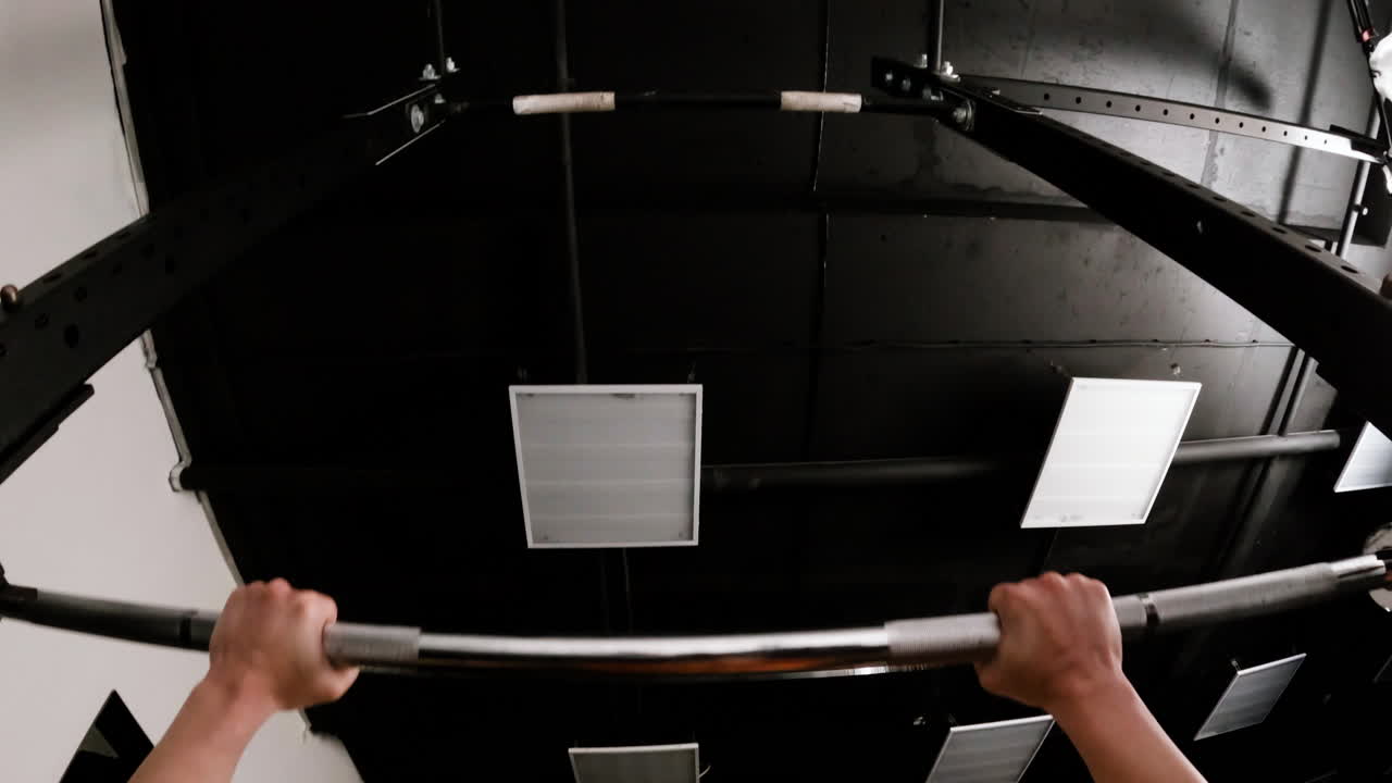 Person Performing Pull-Ups in a Gym