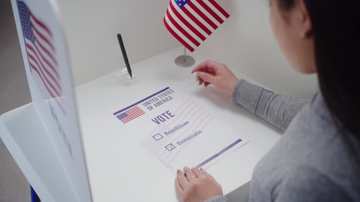 Asian Woman Fills out Paper Ballot Voting for Democratic Party Asian Woman Comes to Voting Booth at Polling Station Fills out Paper Ballot Voting for Democratic Party Female us Citizen during National Election Day in the United States of America Civic Duty