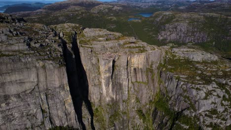 aerial shot across preikestolen plateau, norway. wide lysefjord with mountains in the distance.