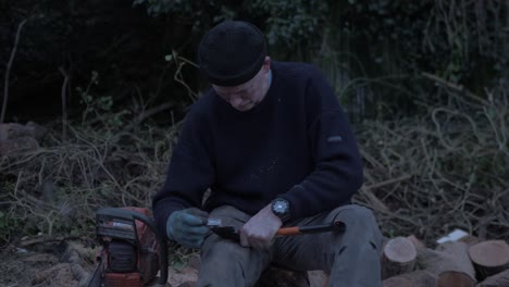 man sharpening axe within nature