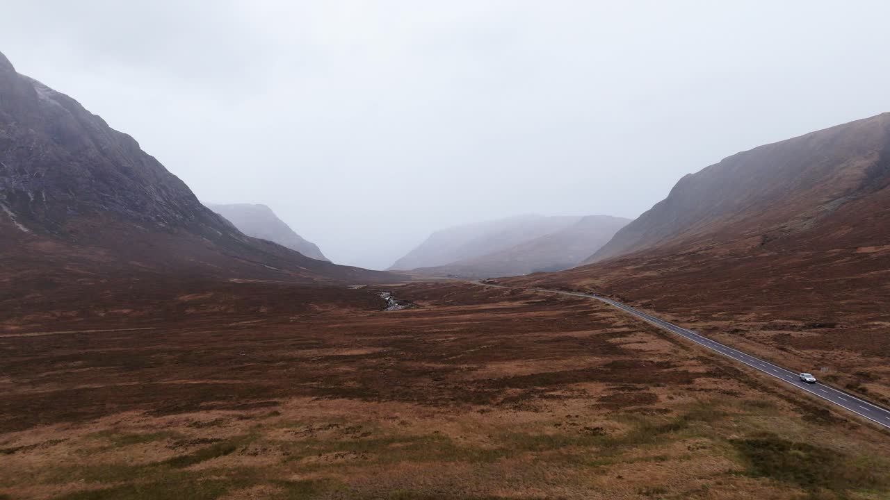 Road through mountain valley wilderness in Glen Etive, Scotland, aerial panorama