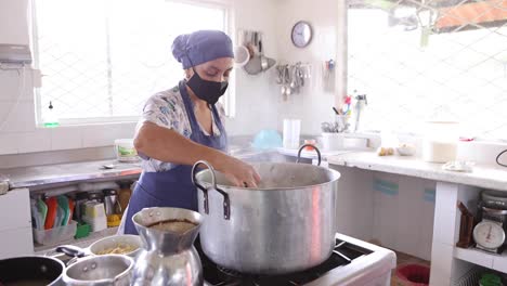 cocinera concentrada cocinando en una olla grande