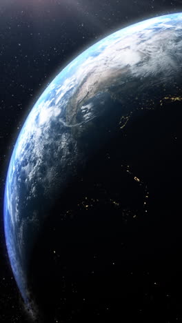 vertical format : a cinematic rendering of planet earth during sunrise as view from space with vibrant blue sky atmosphere