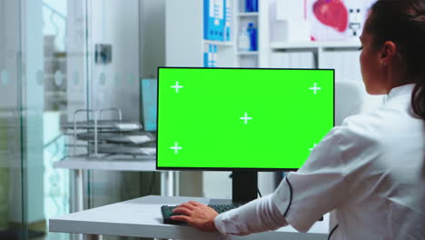 el médico se sienta en la computadora con una pantalla en blanco