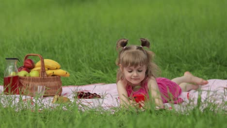 Weekend-at-picnic.-Girl-on-grass-meadow-play-online-games-on-mobile-phone.-Social-network,-chatting