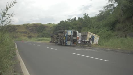 un camión que transportaba un contenedor de almacenamiento en frío se volcó en un accidente debido a un sobreviraje en una sección ghat cuesta abajo en una carretera india en cámara lenta de 4k