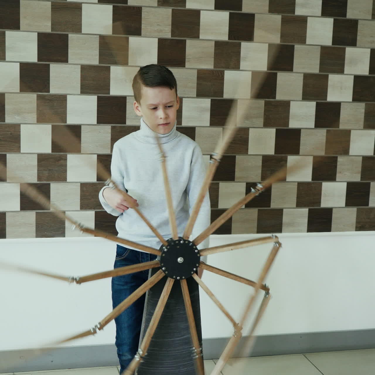 Child looks at the perpetual motion machine in the children's scientific museum. Museum exhibit Square video