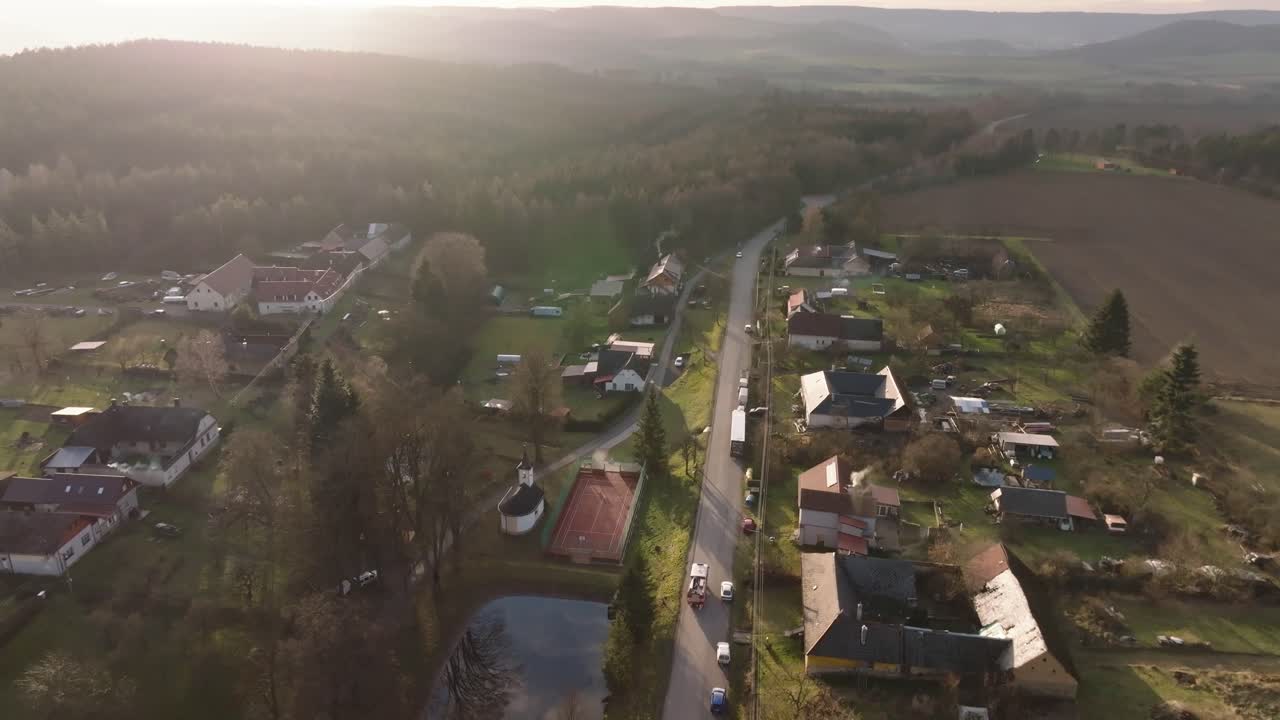 Firefighters drive through a village on a sunny winter day. Aerial view from a drone. Heavy equipment exit. Czech Republic, Europe