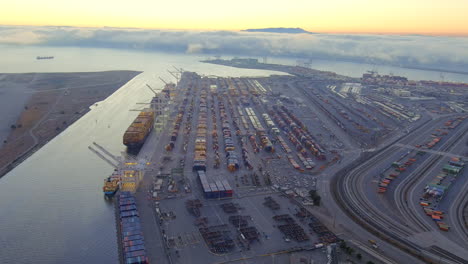 Vista-Aérea-Del-Puerto-De-Oakland-Al-Atardecer-Con-Panorama-De-La-Bahía-De-San-Francisco-En-California,-Estados-Unidos