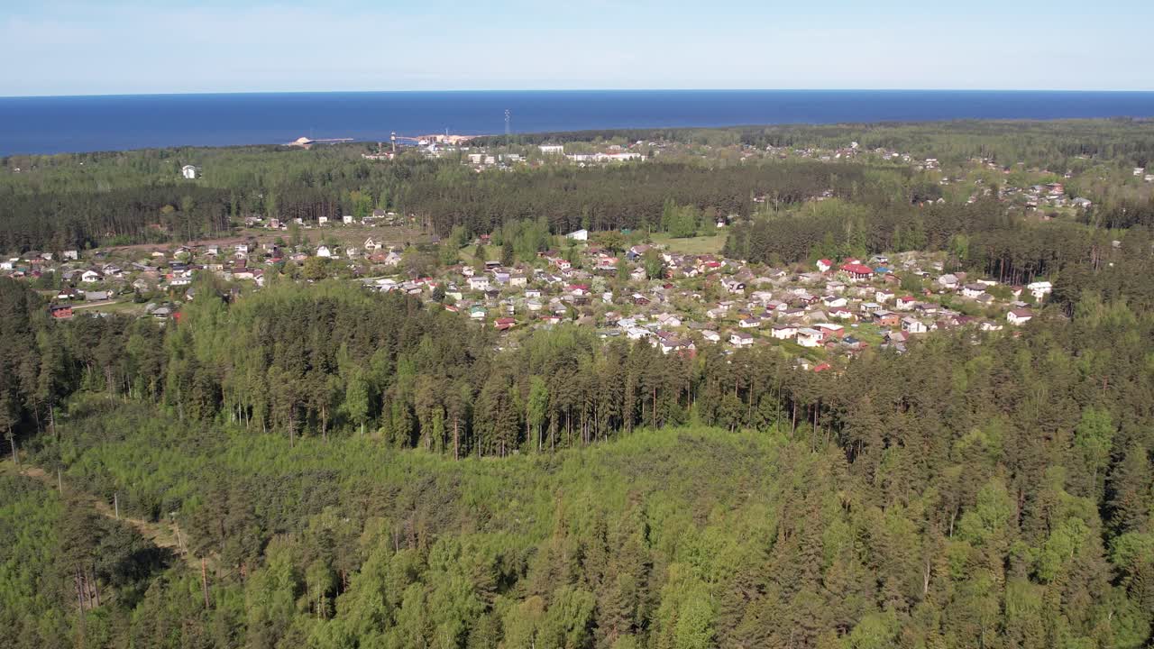 Aerial View of a Coastal Village Surrounded by Forest and Sea