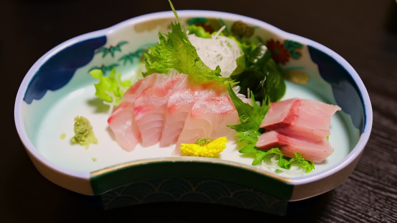 Đĩa sashimi Nhật Bản tươi ngon với cá tráp biển và cá cam trên đồ gốm truyền thống, cận cảnh món ăn