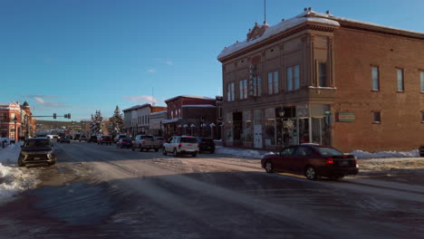 snowy winter day on a town street with cars and buildings