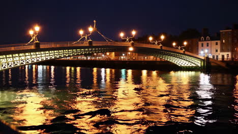 ha'penny bridge over river liffey at night in dublin, ireland