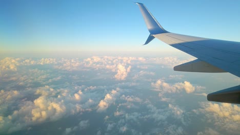 wing of airplane flying above the clouds