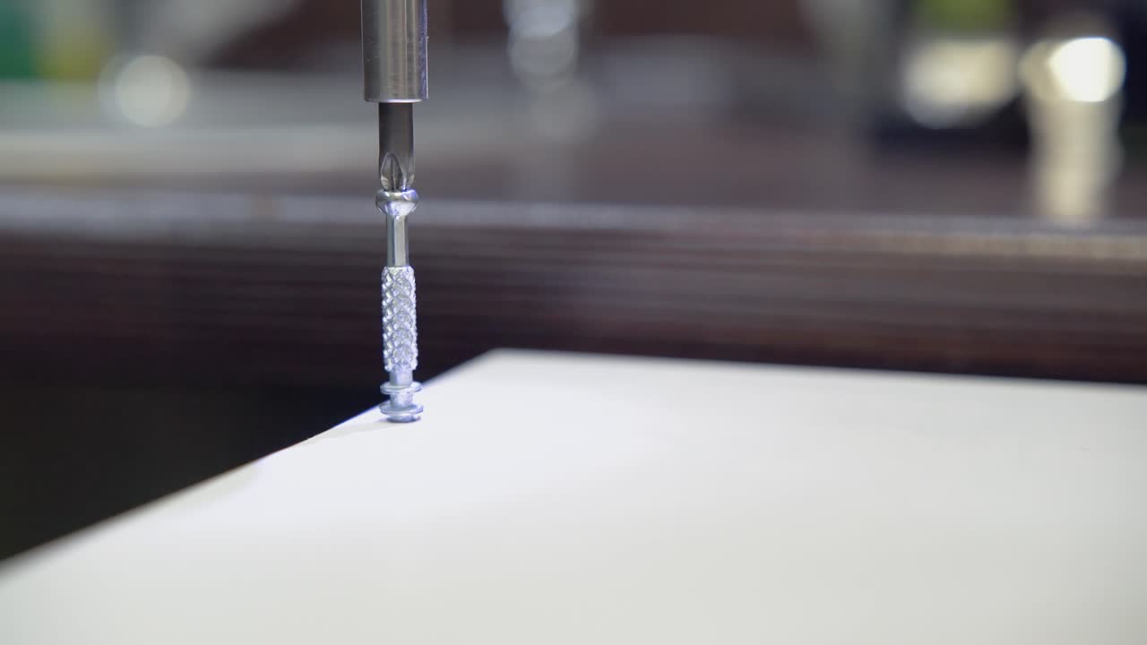 스크루를 스크루드라이버로 테이블 표면에 스크루드라이버 7 스크루드라이버는 회전의 장소를 강조합니다