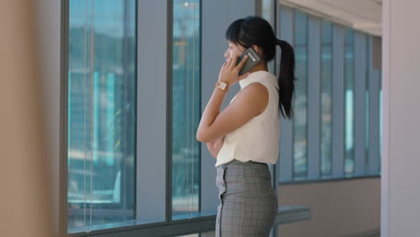 asian-business-woman-using-smartphone-corporate-sales-executive-chatting-to-client-financial-advisor-negotiating-deal-sharing-expert-advice-having-phone-call-in-office-looking-out-window