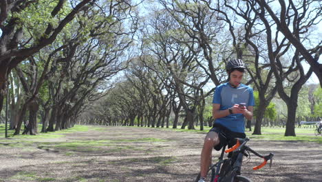 Cyclist Taking Break during Bike Ride and Using Phone