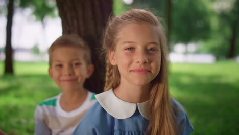 Portrait-of-smiling-children-on-summer-nature.-Happy-siblings-resting-in-park.