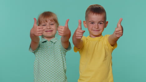 little toddler children boy and girl siblings raises thumbs up, like, agrees or gives positive reply