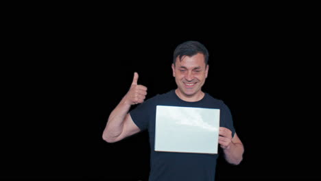 a male model man poses with white blank plate board sheet of paper and points at it with positive emotional reaction on black chromakey transparent removed no background
