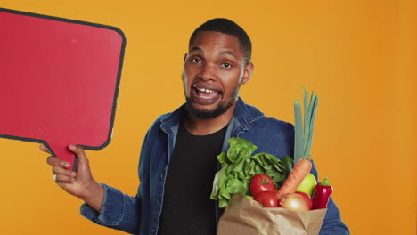 young man showing a speech bubble empty cardboard sign to create an ad