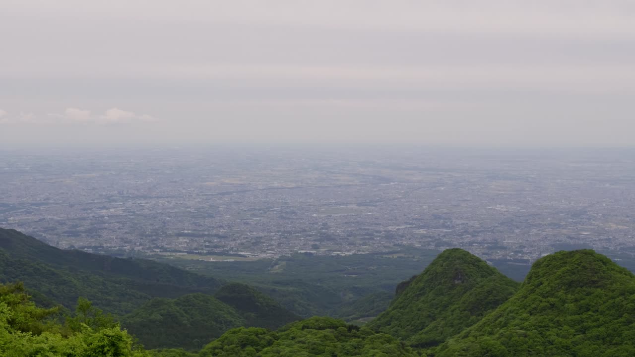 Sweeping panoramic pan over countryside in rural Japan on cloudy day