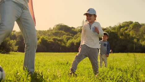 Zwei-Brüder-Spielen-Lachend-Und-Lächelnd-Bei-Sonnenuntergang-Auf-Dem-Feld-Mit-Einem-Fußball.