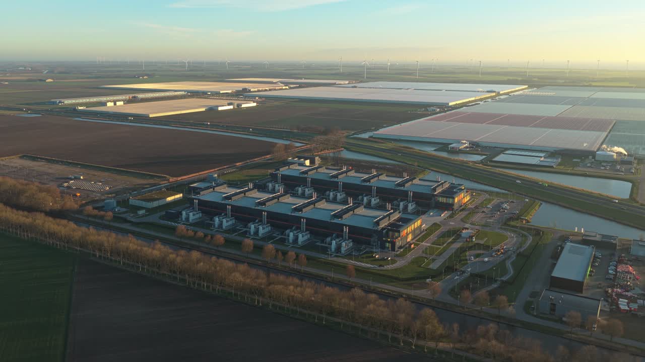 Luftfoto af et moderne datacenteranlæg ved solopgang