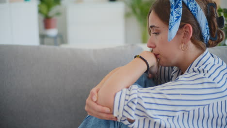 mujer triste a punto de llorar sentada en el sofá