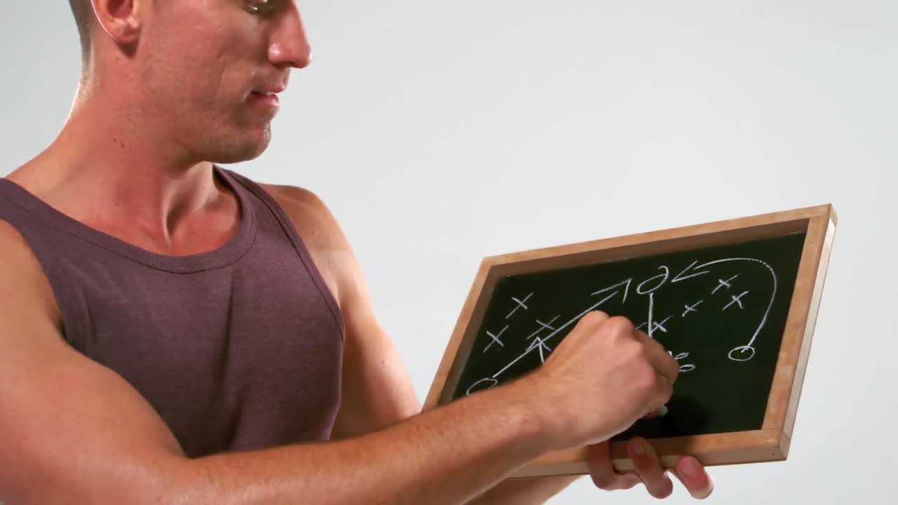 тренер пишет тактику на доске.