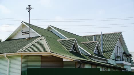 exterior de una casa con techo verde y revestimiento de madera