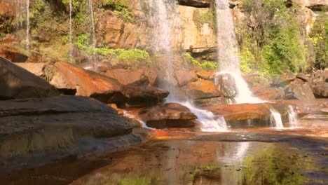 Reflexion-Mit-Unberührtem-Natürlichen-Wasserfall,-Der-Tagsüber-Von-Der-Bergspitze-In-Wälder-Fällt,-Aus-Einem-Anderen-Blickwinkel