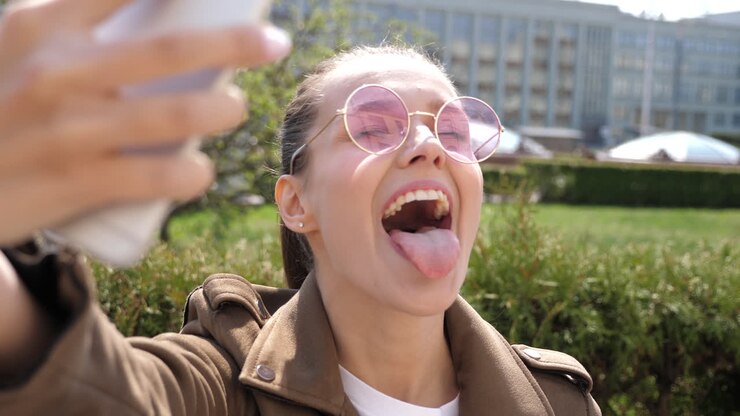 Young woman taking a selfie in the city park