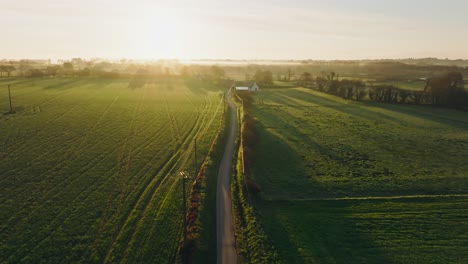 flying over a small country road in the french countryside of bretagne during sunrise